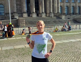 Magdalena Klimek, w Berlinie na tle budynku, trzyma medal w ręku.