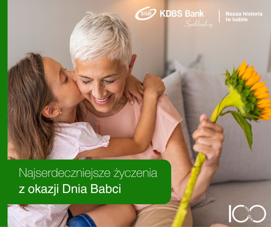 Szczęśliwa wnuczka, całuje w policzek babcię. Babcia w ręku trzyma piękny słonecznik.